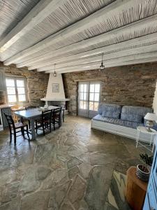ein Wohnzimmer mit einem Sofa und einem Tisch in der Unterkunft The Traditional Stone Villa in Koundouros