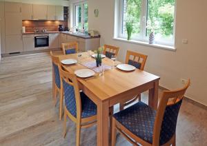 a dining room with a wooden table and chairs at Ferienhaus Am Bienenzaun in Wietzendorf