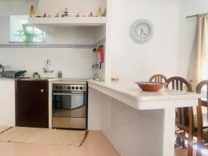 uma cozinha com um balcão, um lavatório e um fogão em Casa do Avô Zé em Caminha