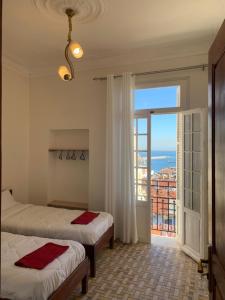 a bedroom with two beds and a large window at AFRIC HOTEL- Casbah in Alger