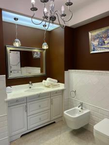 een badkamer met een wastafel, een spiegel en een toilet bij Apartment Porohova in Lviv