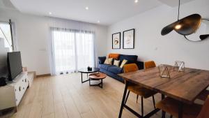 a living room with a table and a blue couch at PANORAMIC design home in Finestrat