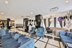 a lobby of a store with blue couches and chairs at Prestige Hotel and Aquapark - All inclusive in Golden Sands