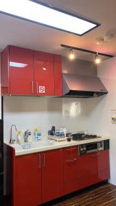 大津的住宿－山水之家，一间带红色橱柜和水槽的厨房