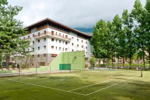 un court de tennis en face d'un bâtiment dans l'établissement RVHotels Condes del Pallars, à Rialp