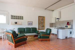 un soggiorno con sedie verdi e tavolo di Pollancre a Vidreres