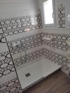 baño con azulejos blancos y negros y espejo en La Villa des Gardies, en Vézénobres