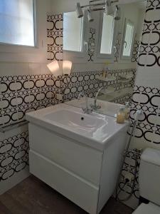 Baño blanco con lavabo y espejo en La Villa des Gardies, en Vézénobres