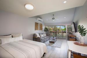 a bedroom with a bed and a living room at Kihei Bay Surf 227 in Kihei