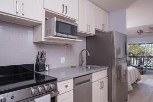 a kitchen with a stainless steel refrigerator and a microwave at Kihei Bay Surf 227 in Kihei
