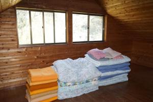 une chambre avec une pile de couvertures dans une cabane en rondins dans l'établissement Dogashima Land Hohia / Vacation STAY 81112, à Tago