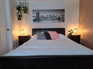 1 dormitorio con 1 cama con 2 mesitas de noche y 2 lámparas en Habitations Zenith en Sainte-Anne-de-Beaupré