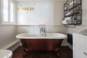 a large tub in a bathroom with a toilet at 2 Clifton Place in Salcombe