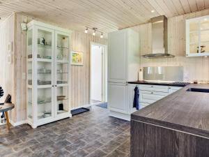 a kitchen with white cabinets and a counter at 2 person holiday home in L s in Læsø