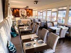 a restaurant with tables and chairs and a bar at Hotel Rummeni in Borkum +13 photos