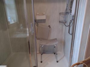 a shower with a chair in a small bathroom at lake District cottage in Bootle