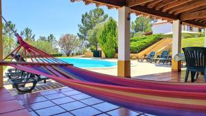 una hamaca en un patio junto a la piscina en Castelo de Bode Monte do Valinho Country house with private pool and panoramic views, en Alverangel