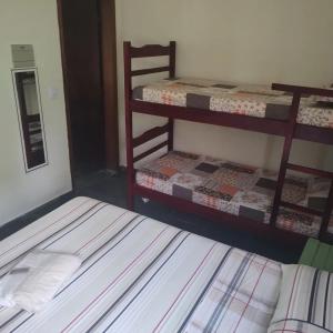 une chambre avec deux lits superposés dans une pièce dans l'établissement Pousada Porto Aventura -Chalés da Luci, à Peruíbe