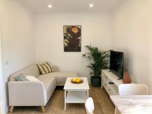 a living room with a white couch and a table at Casa Martins Country Apartment No5 in Freiria