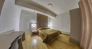 A bed or beds in a room at Grand Hotel Europa Rivisondoli Centro