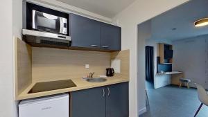 a kitchen with a sink and a microwave at City Résidence Paris Saint-Maurice in Saint-Maurice