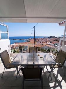 un tavolo e sedie su un balcone con vista sull'oceano di Vaggelitsa's House a Pythagóreion