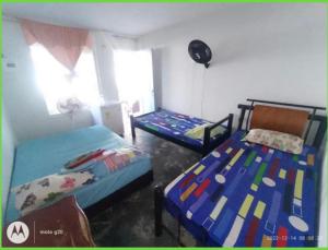 a bedroom with two beds and a window at Cabaña El Paraíso Uveros in San Juan de Urabá