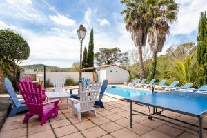 een patio met stoelen, een tafel en een zwembad bij Villa Denis Completa in Vidreres