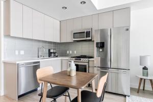 a kitchen with stainless steel appliances and a wooden table at Downtown 1BR w Roof Pool Gym nr the 110 LAX-734 in Los Angeles