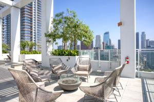 Un grupo de sillas en un balcón con el horizonte de la ciudad. en Downtown 1BR w Roof Pool Gym nr the 110 LAX-734, en Los Ángeles
