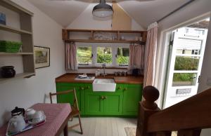 una cucina verde con lavandino e tavolo di Applecote a studio apartment for two Rye, East Sussex a Rye