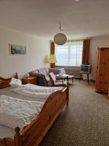 a bedroom with a large bed and a living room at Landgasthof Restaurant Laibach in Bad Berleburg