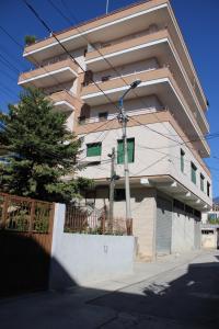 a building with a fence in front of it at Deni's Family Apartment in New BLVD in Tirana