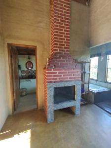 a brick fireplace in a room with a brick wall at Chalés Kayoá in Córrego do Bom Jesus