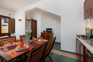 a dining room with a table and a kitchen at Case vacanza Al Paradise in San Vito lo Capo