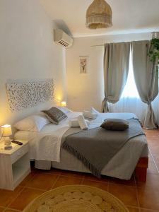 - une chambre avec un grand lit et une fenêtre dans l'établissement B&B La Pitraia, à Sant Antonio Di Gallura