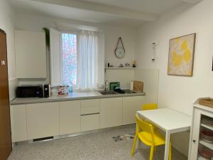 a kitchen with white cabinets and a table and a window at 8+8 Appartamento con garage in Livorno