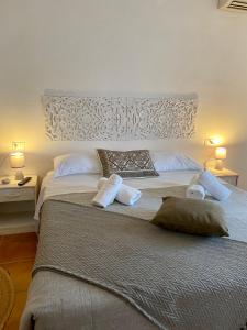 een slaapkamer met een groot bed met 2 kussens bij B&B La Pitraia in Sant Antonio Di Gallura