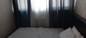 een ongeëvenaard bed in een slaapkamer met een raam bij Charming 2-Bed Apartment in London in Londen