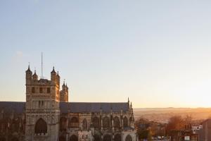 an old cathedral with the sun shining on it at Hotel Indigo - Exeter, an IHG Hotel in Exeter