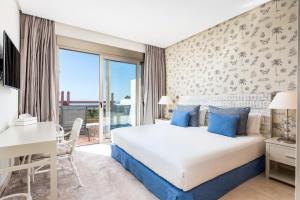 a hotel room with a bed and a desk and a window at Las Terrazas de Abama Suites in Guía de Isora