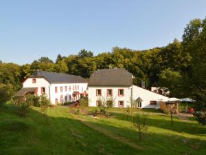 ein paar weiße Häuser auf einem Grasfeld in der Unterkunft Country house with private garden in Heidweiler