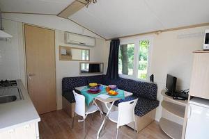 a small kitchen with a table and chairs in a caravan at Camping Village Costa Verde in Porto Potenza Picena