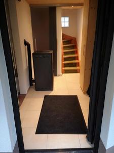 a hallway with a black rug and stairs in a house at Ruhig gelegenes Ferienhaus in Simmelsdorf