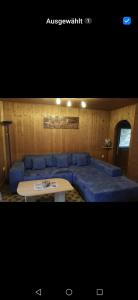 a living room with a blue couch and a table at Ruhig gelegenes Ferienhaus in Simmelsdorf