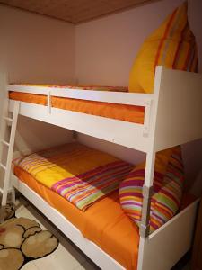 SimmelsdorfにあるRuhig gelegenes Ferienhausの小さな部屋の二段ベッド2台 オレンジ色