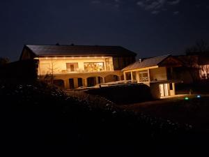 ein Haus in der Nacht mit eingeschaltetem Licht in der Unterkunft Urlaubsoase Hügelperle in Bad Gleichenberg