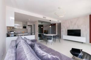 a living room with a large couch and a kitchen at Beferent Los Arenales playa 2 in Arenales del Sol