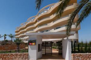 a building with a palm tree in front of it at Beferent Los Arenales playa 2 in Arenales del Sol
