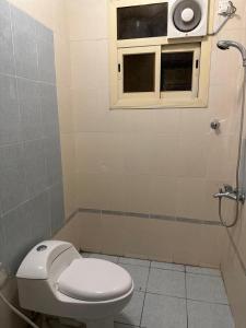 baño con aseo y ventana en المبيت 3 للشقق الفندقية en Abha